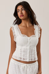 Mad-ly white lace corset blouse with a square neckline, pleated bodice, and ruffled cap sleeves on a model.